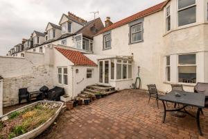 a patio with a table and chairs in front of a house at Appleton House - Lower Largo in Lower Largo