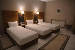 a hotel room with two beds and two tables at Hotel karim Tunis in Tunis +31 photos