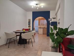 ein Wohnzimmer mit Tisch und Stühlen und eine Küche in der Unterkunft Faros in Paphos City