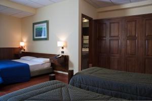 Postel nebo postele na pokoji v ubytování Corsaro Etna Hotel&SPA