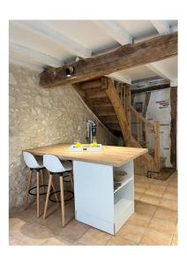 a kitchen with a counter and two stools at La Pierre Pourpre in Eymet