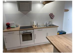 a kitchen with white cabinets and a sink and a counter at La Pierre Pourpre in Eymet
