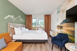 a hotel room with a bed and a tv at aja Ruhpolding in Ruhpolding