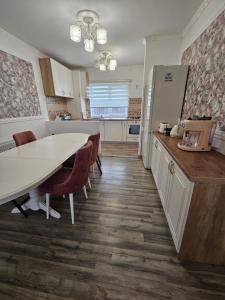 a kitchen with a table and chairs and a refrigerator at Rowlands Way 1 in Ţegheş