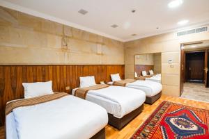 a row of three beds in a room at GHERDAN GOLD OTEL in Konya +32 photos