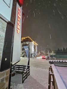 a gas station with a sign in the snow at Private Suite at Comfort Bansko in Bansko
