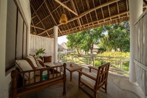 a porch with a couch and chairs and a table at Diamonds Malindi in Malindi +93 photos