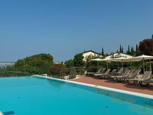a swimming pool with chairs and umbrellas at Paviljoni Omorika in Crikvenica