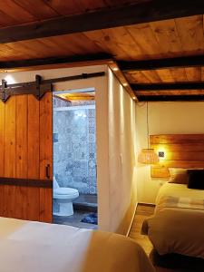 a bedroom with two beds and a bathroom with a toilet at Casa de Campo Huasca - Centro in Huasca de Ocampo +38 photos
