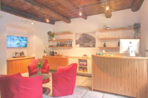an office with red chairs and a desk with a computer at MyVerzasca Boutique Hotel in Brione