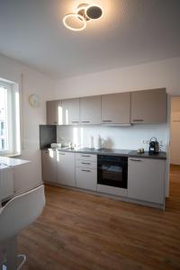 a kitchen with white cabinets and a table in it at JS-Business in Balingen