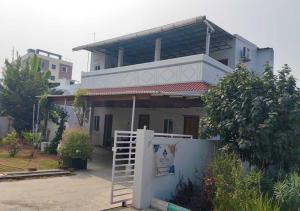 a house with a white gate in front of it at Kostha Suites in Anumalkudūru