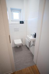 a white bathroom with a toilet and a sink at JS-Business in Balingen +21 photos