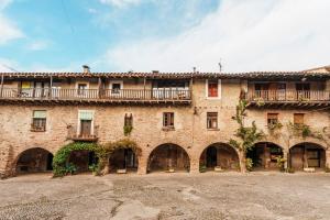 a large brick building with balconies on it at Allotjaments Plaça Major-Aulina in Santa Pau