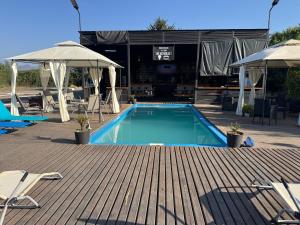 a swimming pool with chairs and umbrellas on a deck at El Rincon Secreto in Quillota