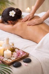 a woman getting a massage on a bed with a tray of candles at Haus im Herrengrund in Schollbrunn