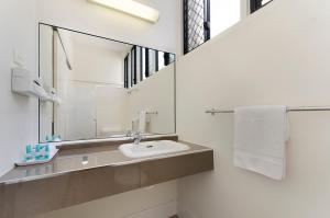 a bathroom with two sinks and a mirror at Beach House Motel in Townsville