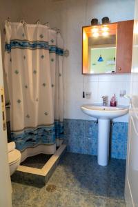 a bathroom with a sink and a shower curtain at InstaView Tolo 2 in Tolo +39 photos