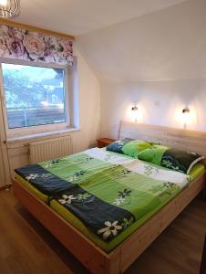 a large bed in a room with a window at Apartmaji Verica Ceklin in Bohinj