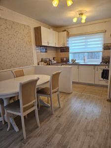 a kitchen with a table and chairs in a room at Rowlands Way 3 in Ţegheş