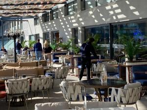 a man standing in a restaurant with tables and chairs at Rıversıdelıfe Iskele 164 in Vuda