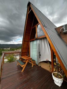 a house with a wooden deck with a chair on it at Chalé nascer do sol in Massaranduba