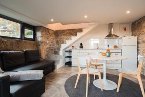a kitchen and a living room with a table and chairs at Villa Seara - Casas da Vinha in Celorico de Basto