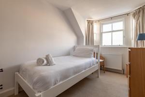 a white bedroom with a bed and a window at School Wynd No 6 - Elie in Elie
