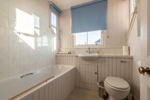 a bathroom with a tub and a toilet and a sink at School Wynd No 6 - Elie in Elie