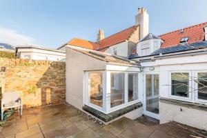 a house with sliding glass doors on a patio at School Wynd No 6 - Elie in Elie