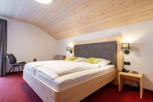 a bedroom with a large bed with a wooden headboard at Hotel Restaurant Frühlingsgarten in Füssen +80 photos