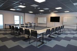 a conference room with a table and chairs and a screen at Apartments Klövsjöfjäll in Klövsjö