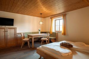 a bedroom with a bed and a table and a dining room at Garni Tschutscherhof in Laion