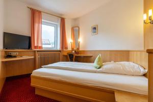 a hotel room with a bed and a television at Hotel Restaurant Frühlingsgarten in Füssen
