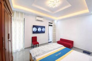 a bedroom with a bed and two red chairs at Anh Đào 2 Hotel in Hai Phong
