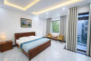 a bedroom with a bed and a table and chairs at Anh Đào 2 Hotel in Hai Phong