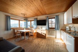 a kitchen and dining room with a table and a kitchen and a room at Garni Tschutscherhof in Laion