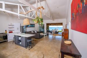 a kitchen and living room with a couch and a table at Highrocks Beach House in Umkomaas
