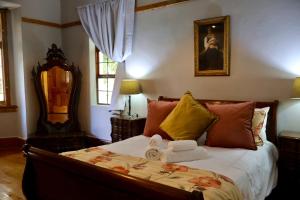 a bedroom with a bed with towels on it at The Dullstroom Inn in Dullstroom
