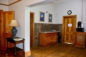 a room with a sink and a table with a lamp at The Dullstroom Inn in Dullstroom +28 photos