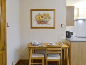 a kitchen with a wooden table with chairs and a painting at Toab - Uk5662 in Aberdeen