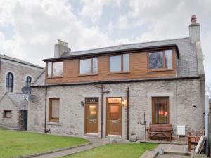 a home with wooden doors and a stone building at Toab - Uk5662 in Aberdeen