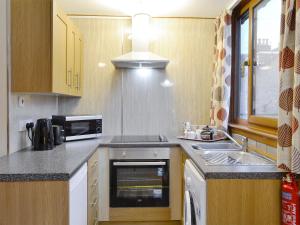 a small kitchen with a sink and a microwave at Toab - Uk5662 in Aberdeen +3 photos