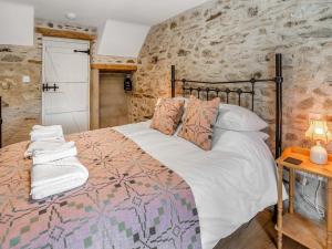 a bedroom with a bed and a stone wall at Ty Gladys in St. Davids +19 photos
