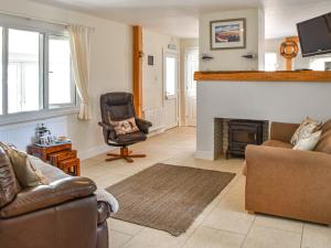 a living room with a chair and a fireplace at The Seas Beach House in Bacton