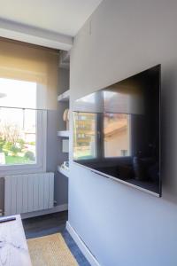 ein Wohnzimmer mit einem großen Flachbildfernseher an der Wand in der Unterkunft Arbide Suite in Leioa
