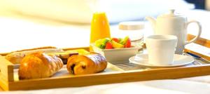a tray of food with bread and fruit on a table at Hotel Thermes Les Ecureuils-Dax in Dax