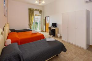 a bedroom with two beds and a tv and a cabinet at Sisters Hotel in Piano di Sorrento