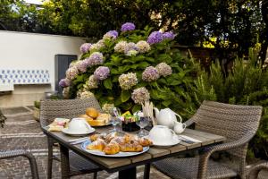 a table with food and tea on it with flowers at Sisters Hotel in Piano di Sorrento