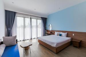 a bedroom with a large bed and a couch at Cocohamlet Villa in Thanh Ðông (1)